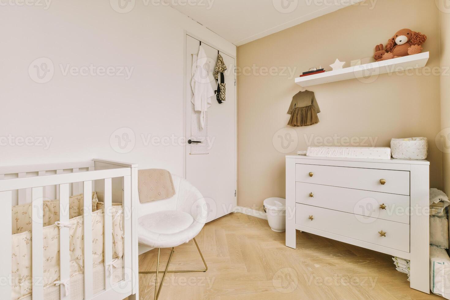 A white crib in a room with a wooden floor photo