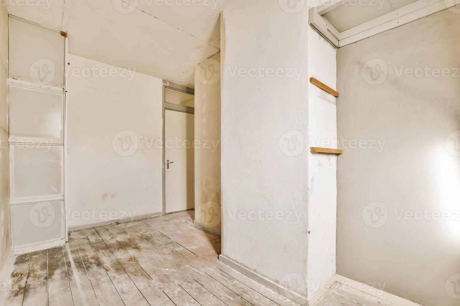 An empty room with wood floors and a door photo