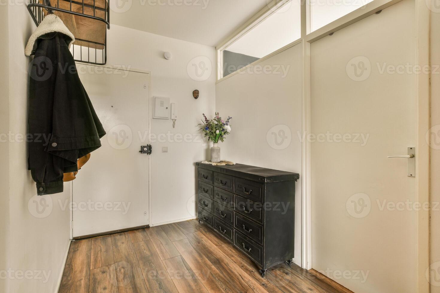 A hallway with a wooden floor and a coat rack photo