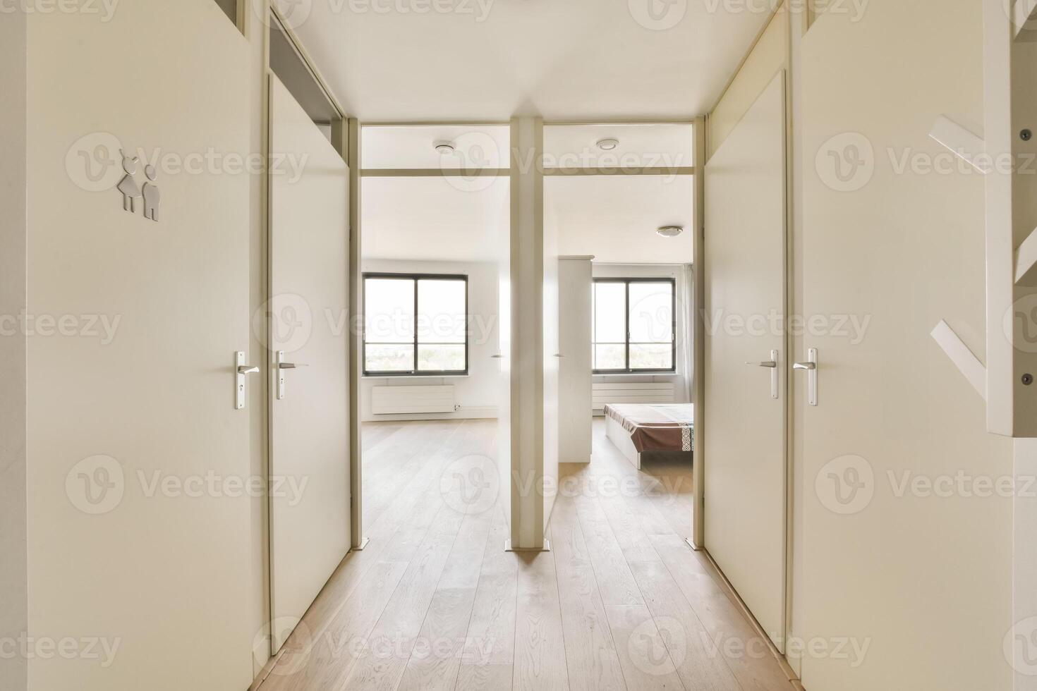 A hallway with two doors and a bed photo