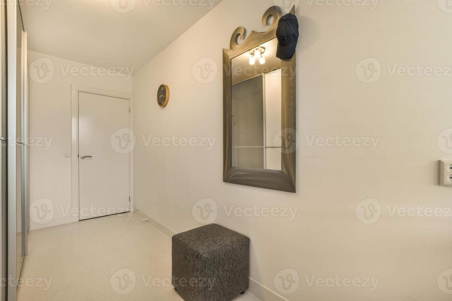 A hallway with a mirror and a bench photo