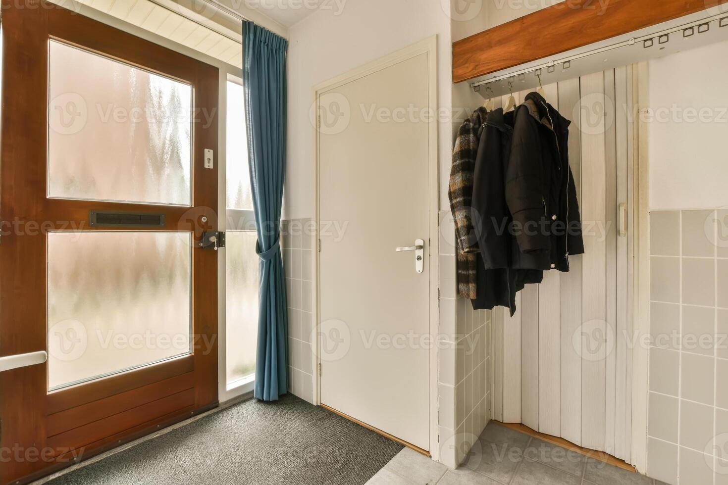 A hallway with a coat rack and a door photo