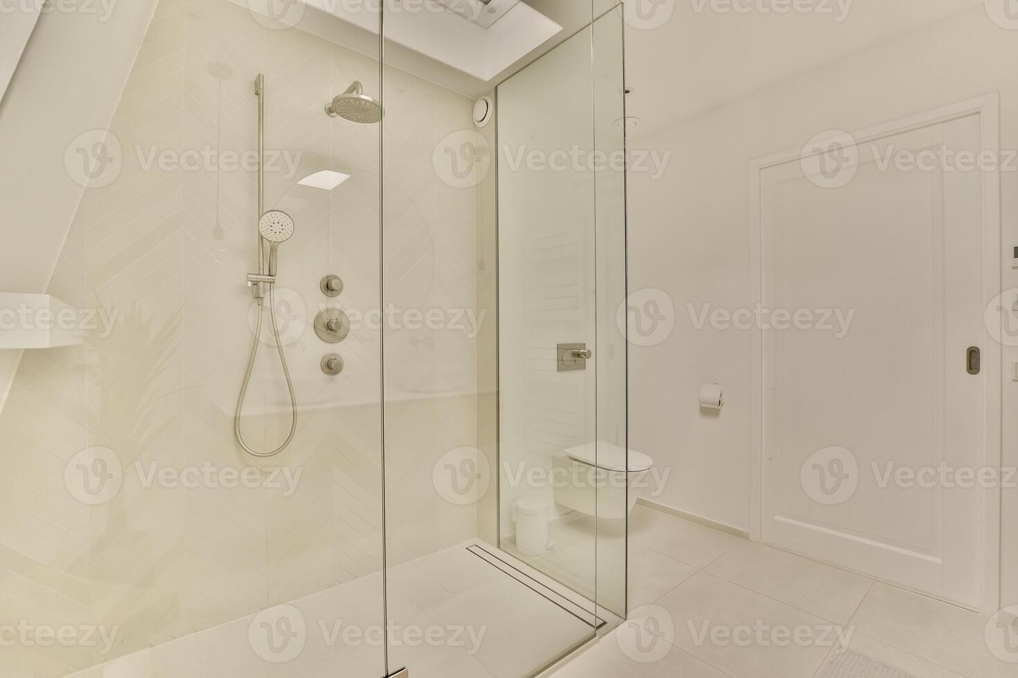 A bathroom with a glass shower door and a toilet photo