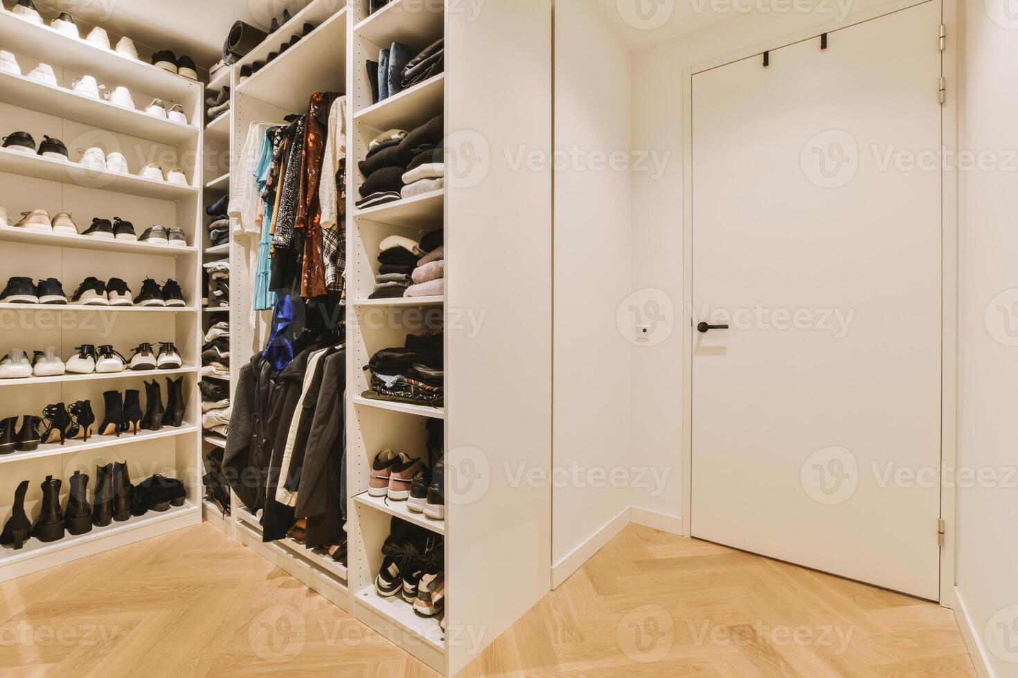 A walk in closet with shoes and clothes photo