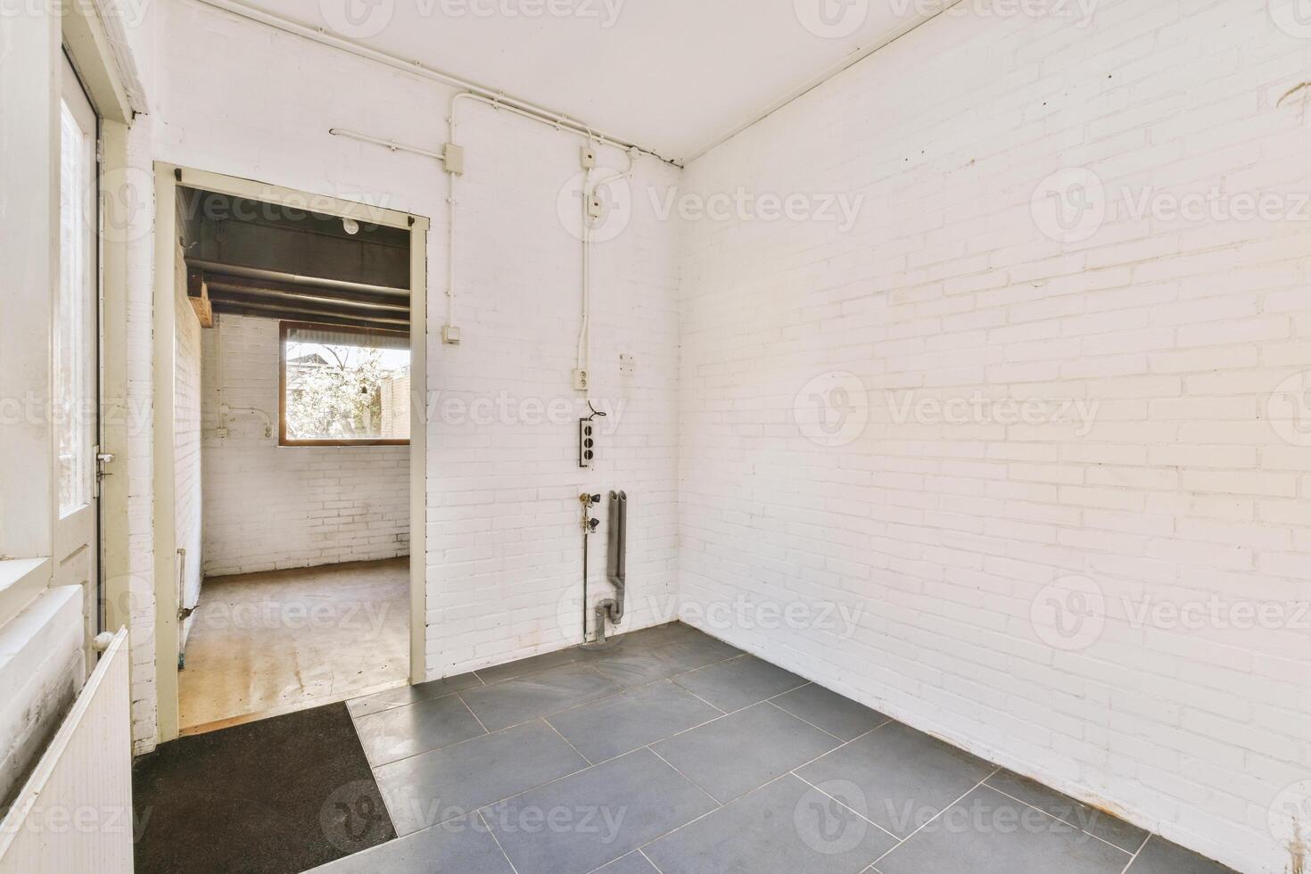 An empty room with a brick wall and a door photo
