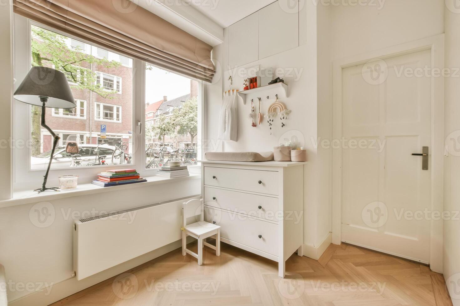 A small room with a white dresser and a window photo