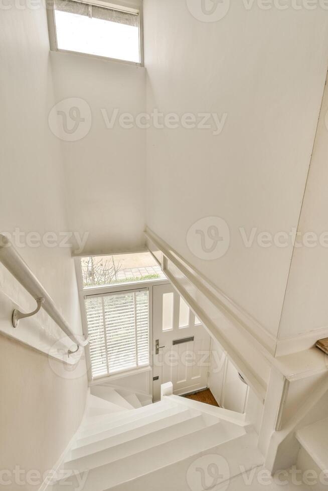 A white stairway with a window and a door photo