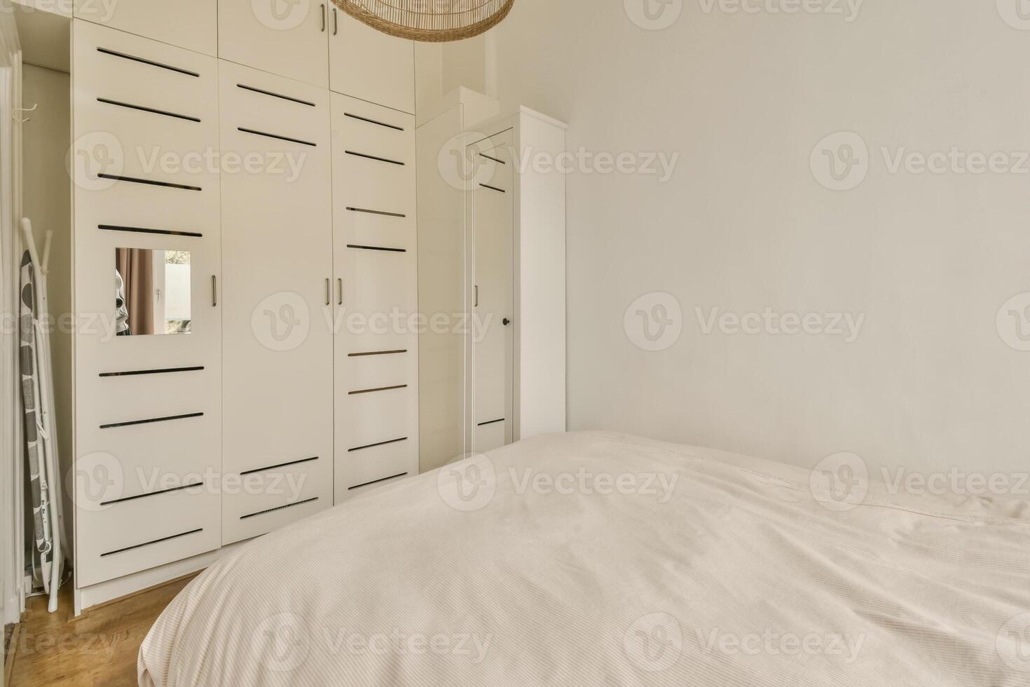 A bedroom with white walls and a bed photo