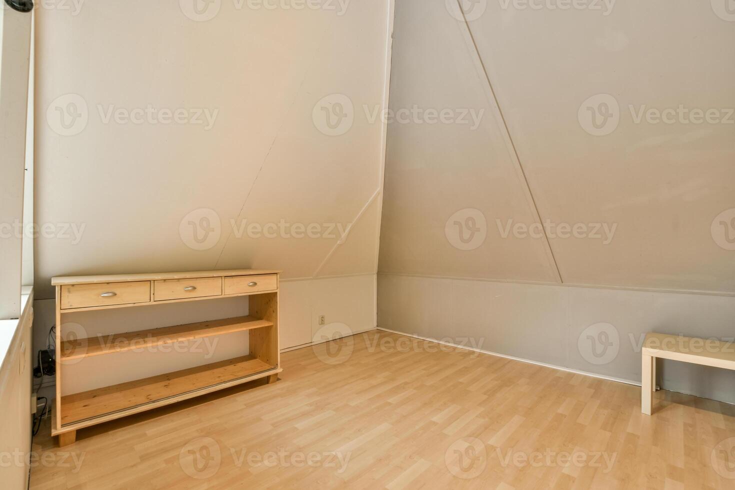 An empty room with a bed and a desk photo