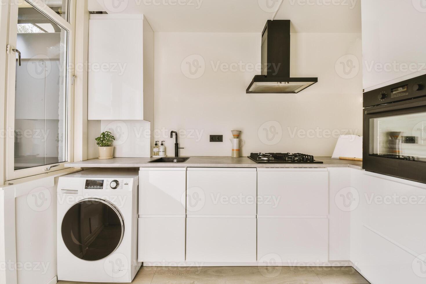 A white kitchen with a washer and dryer photo