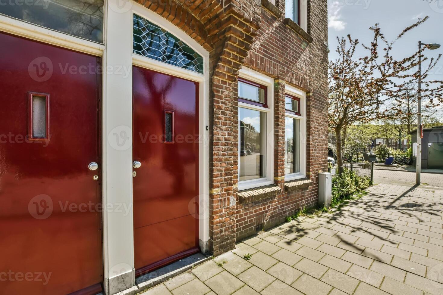 A red door is open on a brick building photo