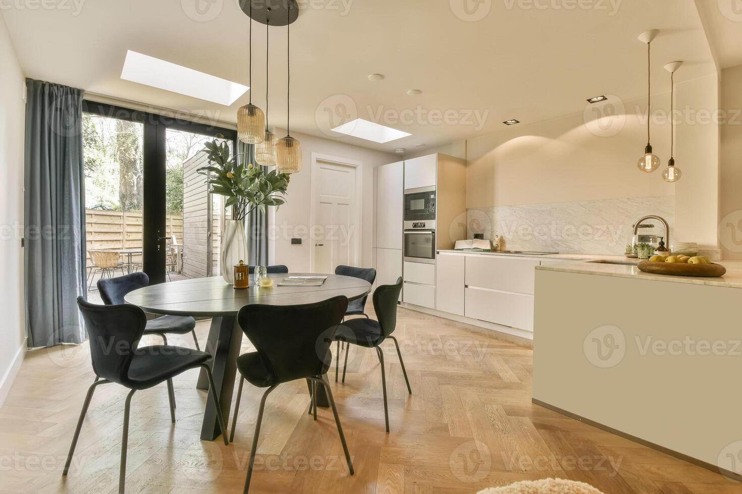 A kitchen and dining area with a dining table and chairs photo