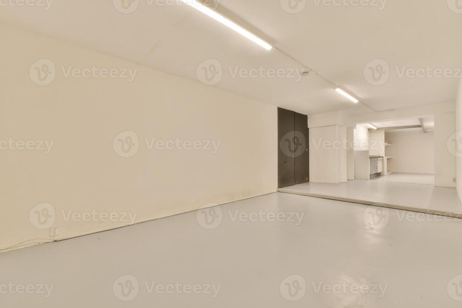 An empty room with white walls and a white floor photo