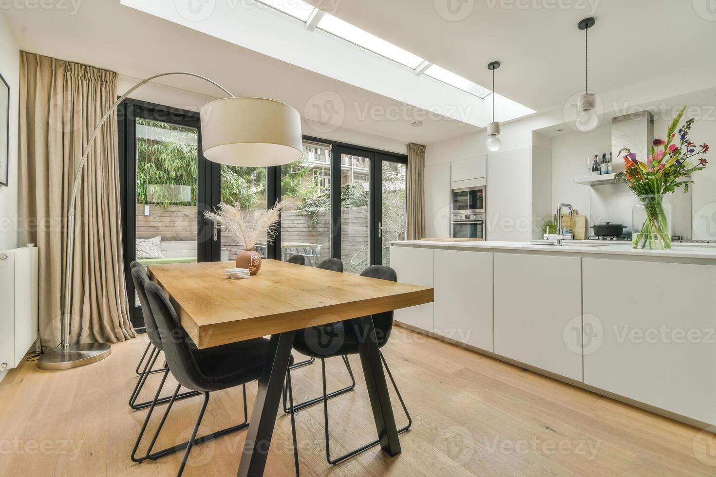 A modern kitchen with a dining table and chairs photo