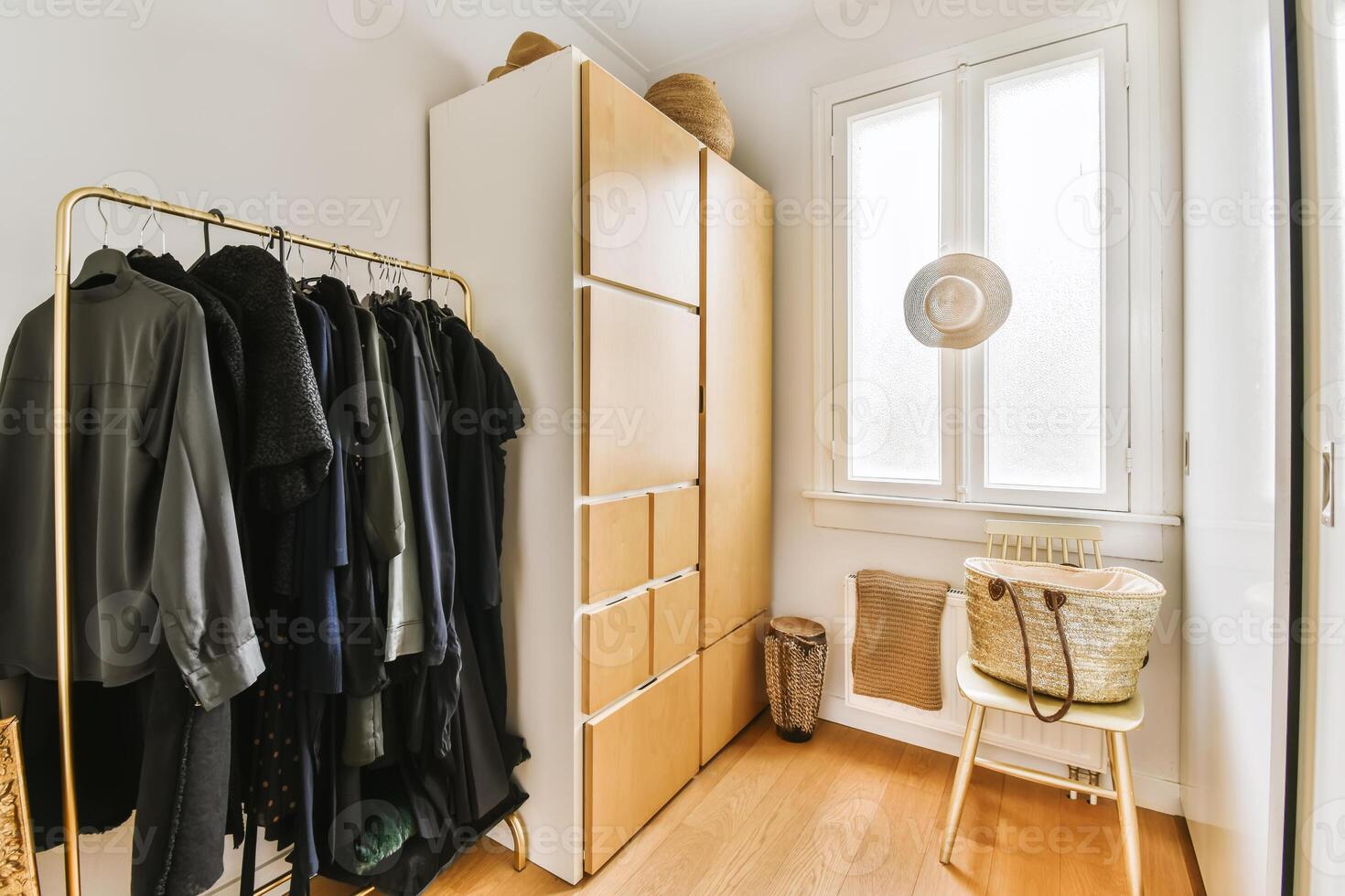 A room with a wooden floor and a closet with clothes photo