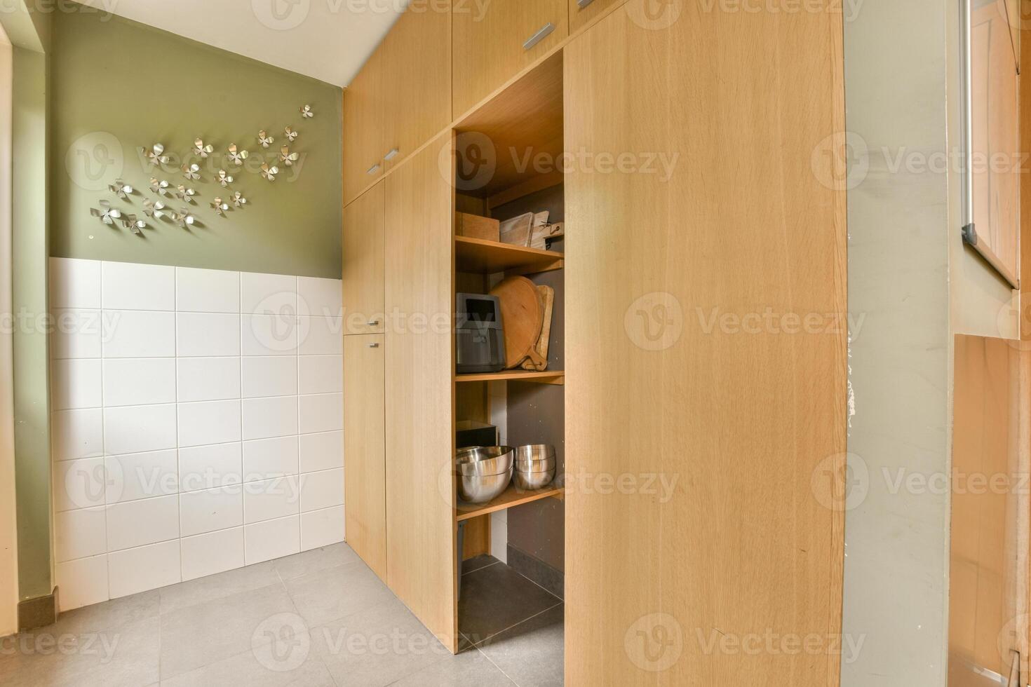 A kitchen with a wooden cabinet and shelves photo