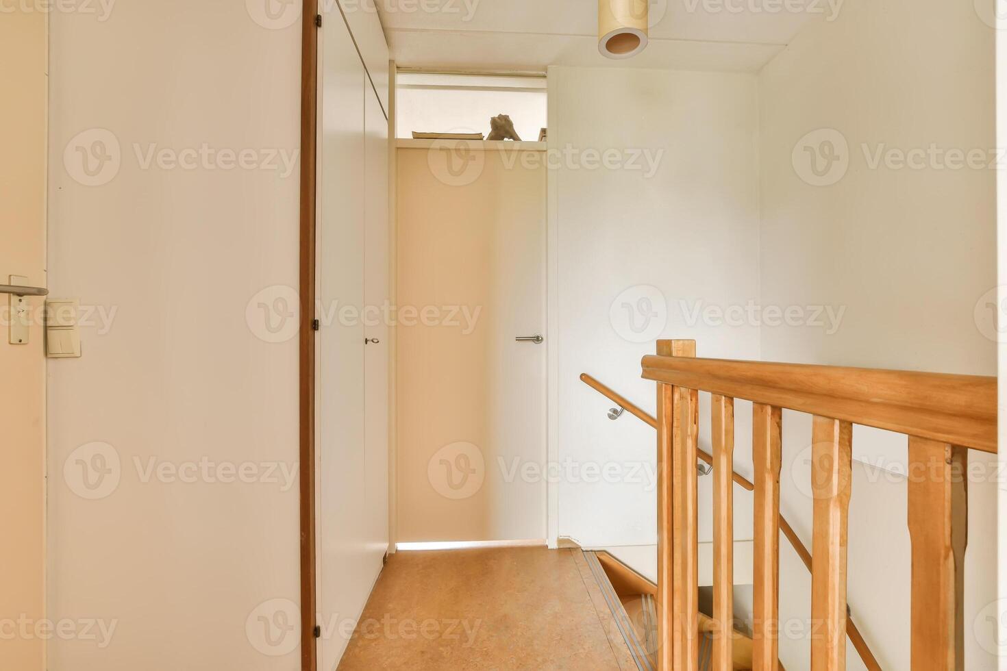 A hallway with a wooden railing and a door photo