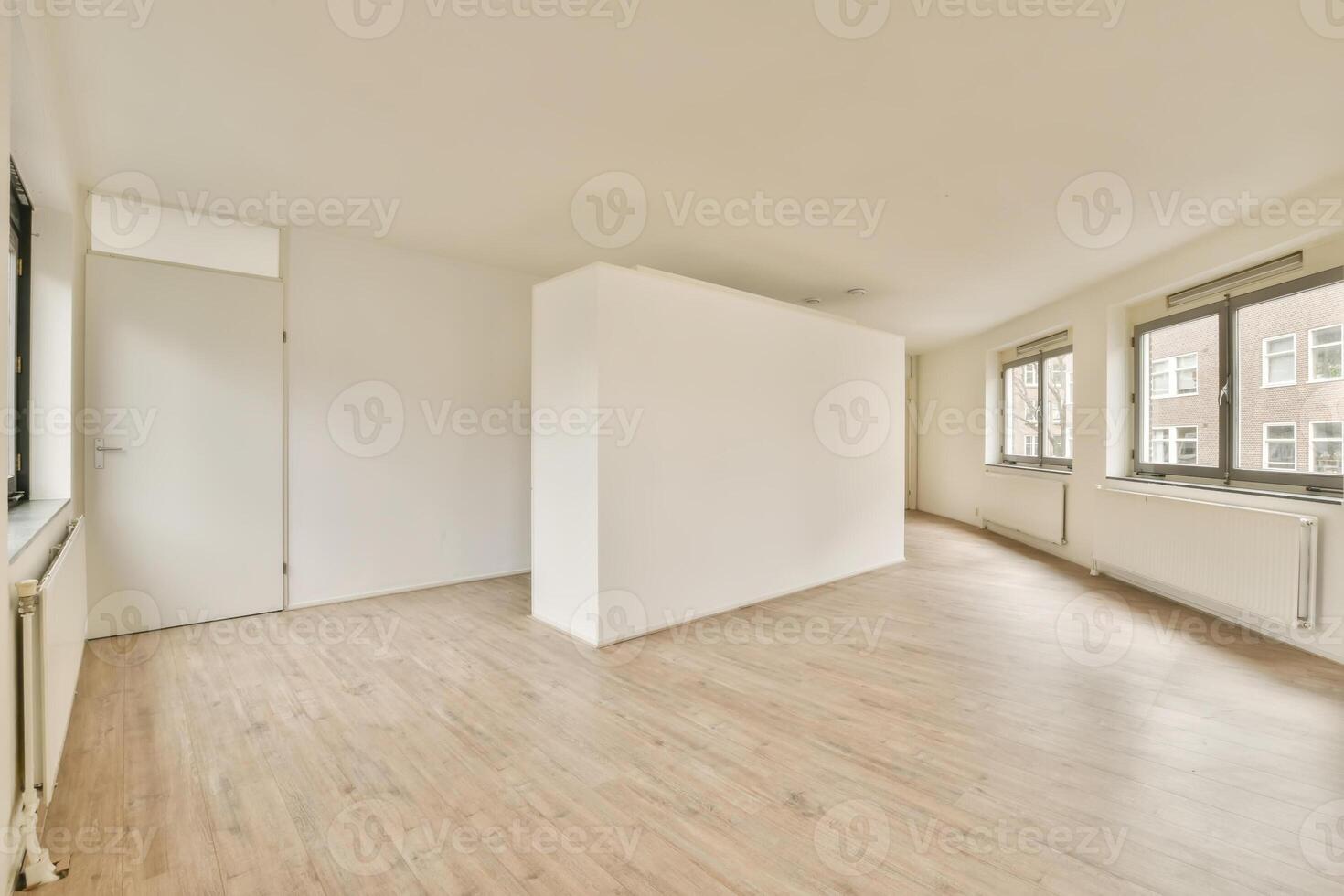 An empty room with wooden floors and white walls photo