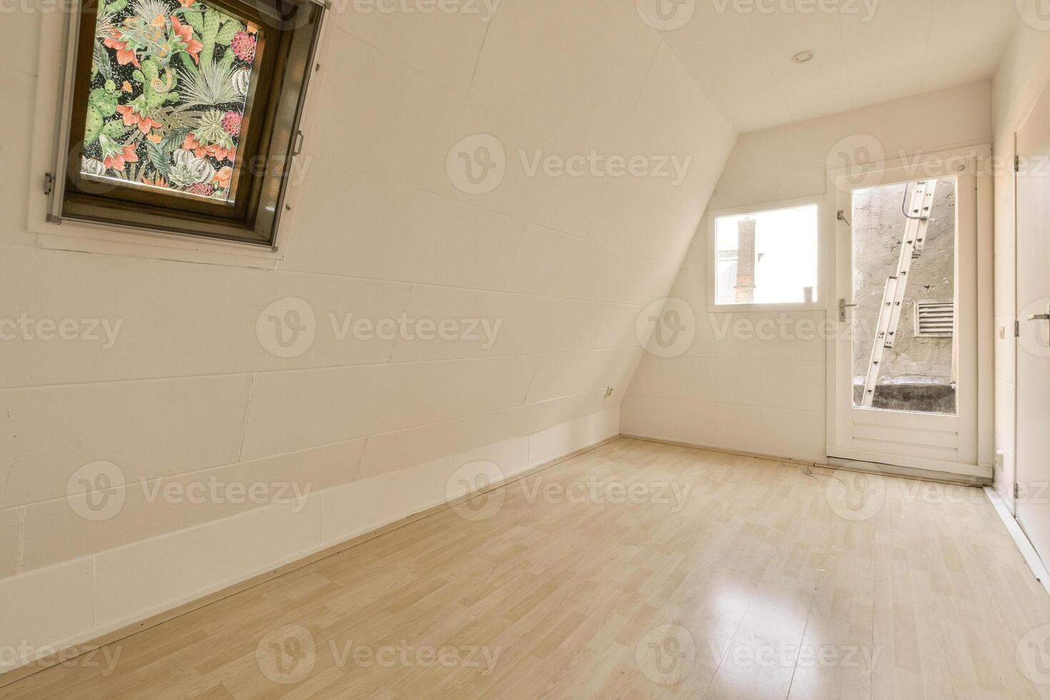 An empty room with a window and wooden floors photo