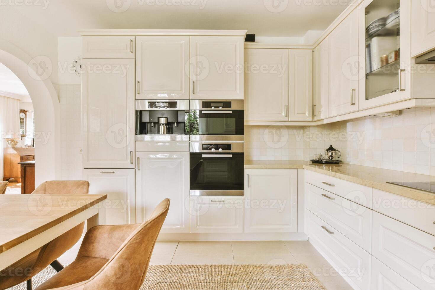 A white kitchen with a table and chairs photo