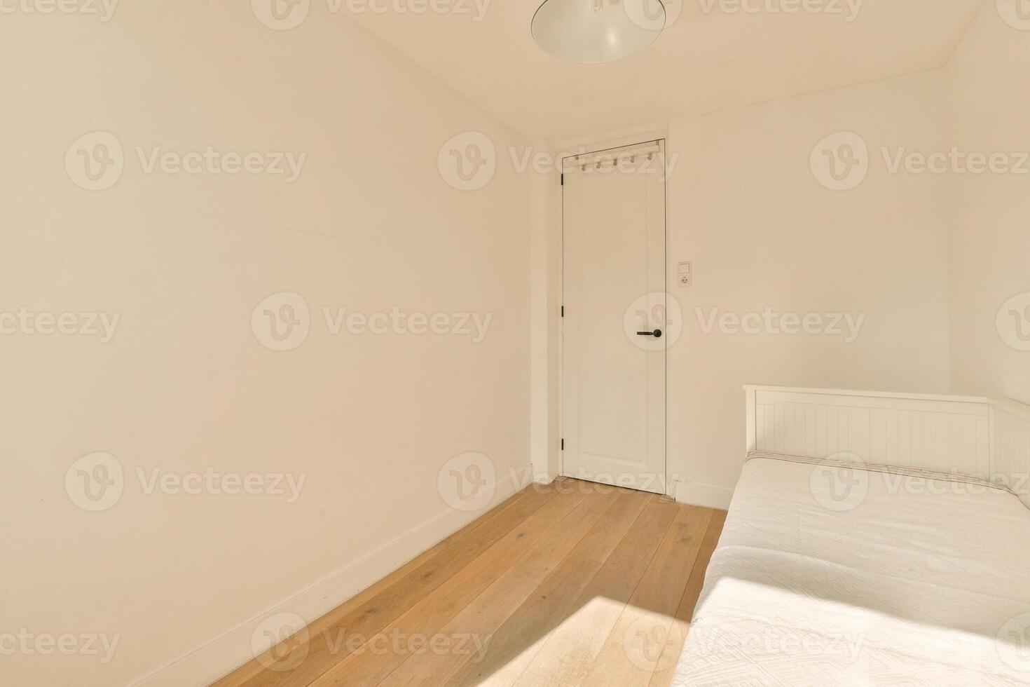 A small room with a bed and a door photo