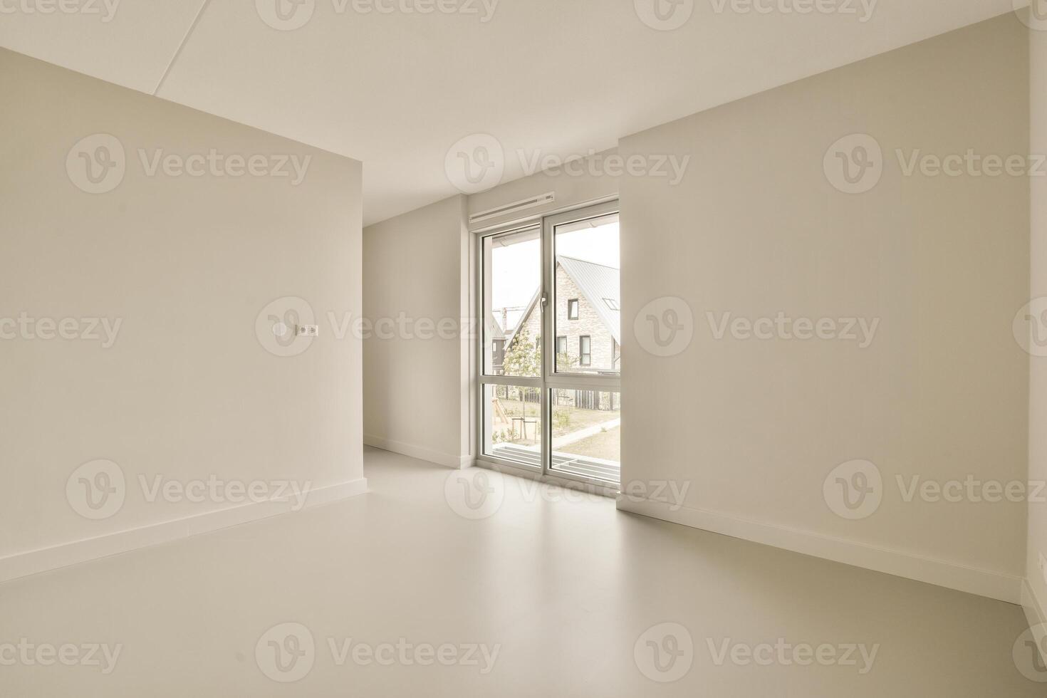 Empty room with white walls and a large window photo