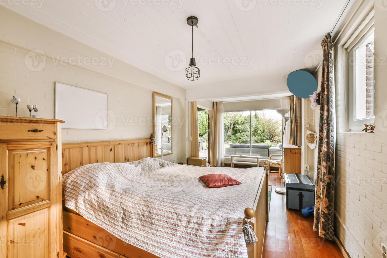 A bedroom with a bed, dresser and a window photo