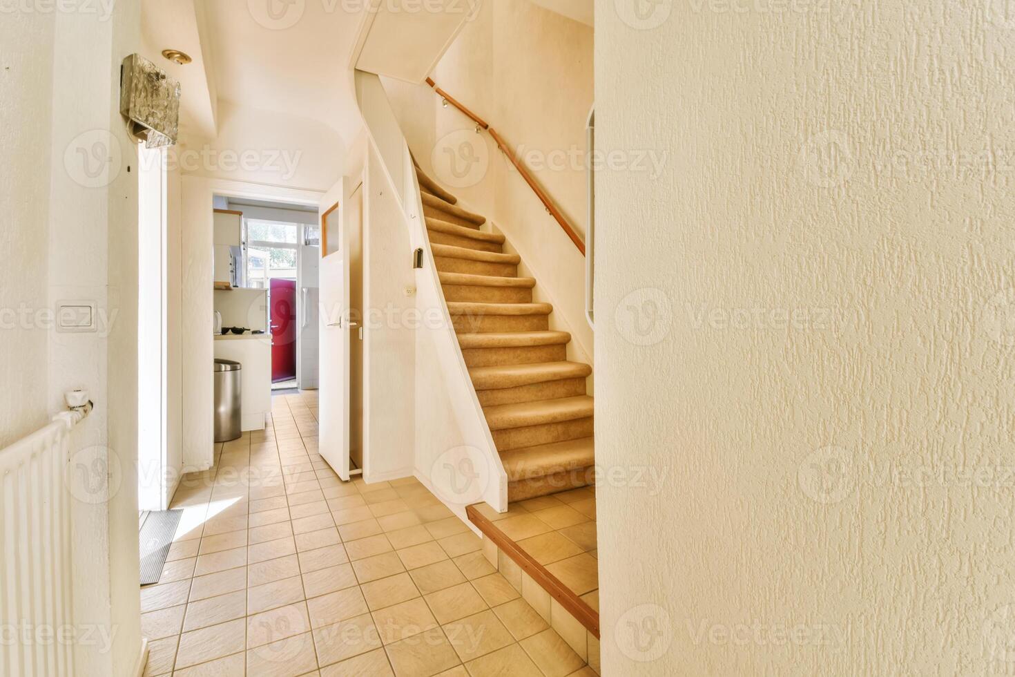 A hallway with a staircase leading up to a room photo