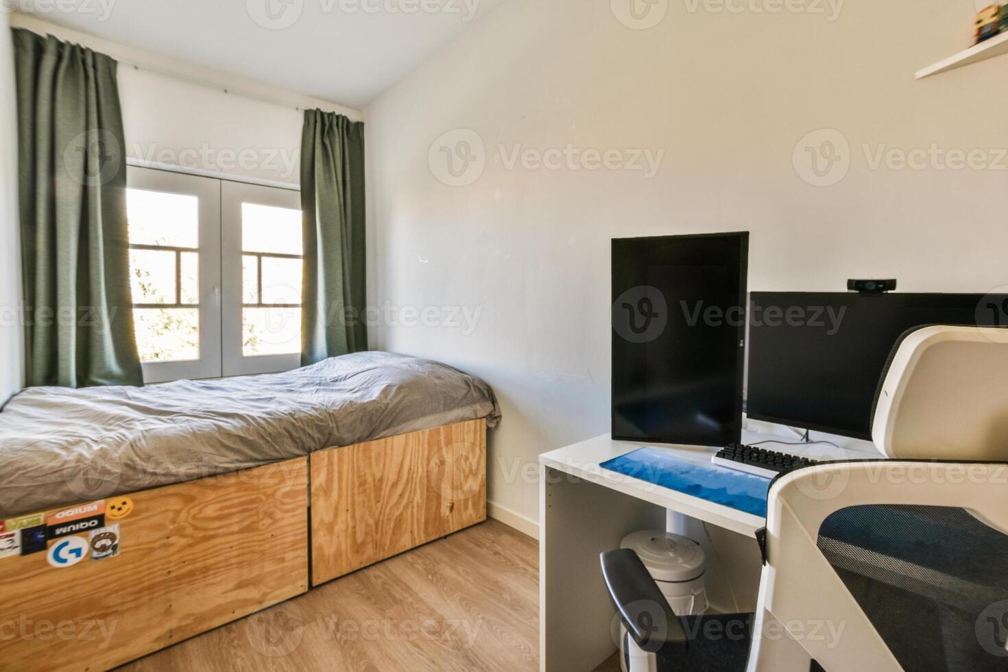 A bedroom with a bed, desk and window photo