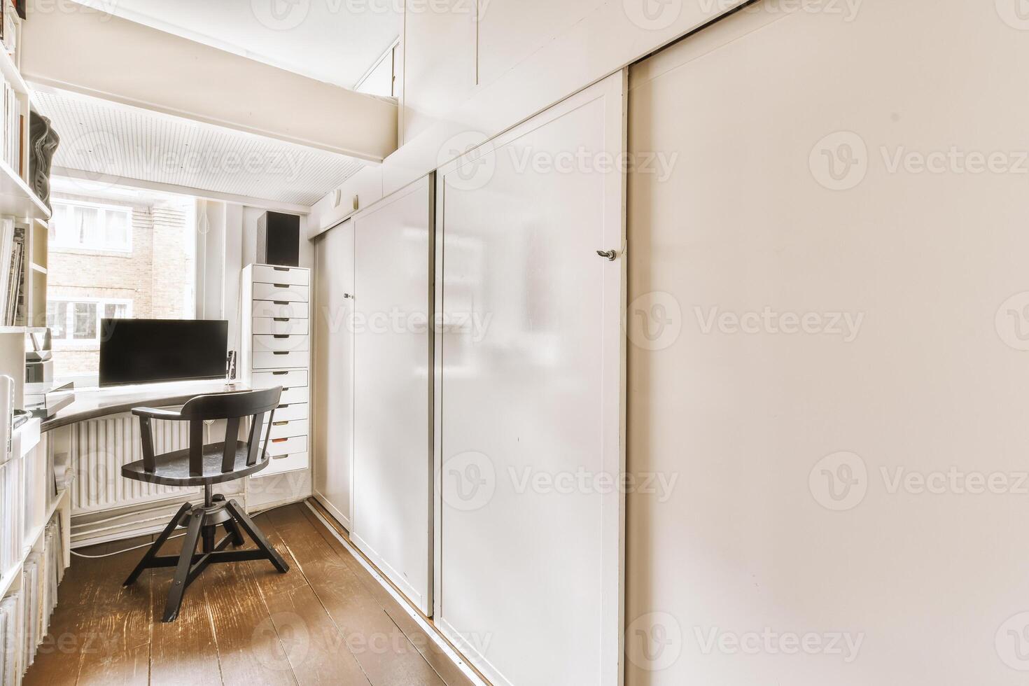 A small office with a desk and a chair photo