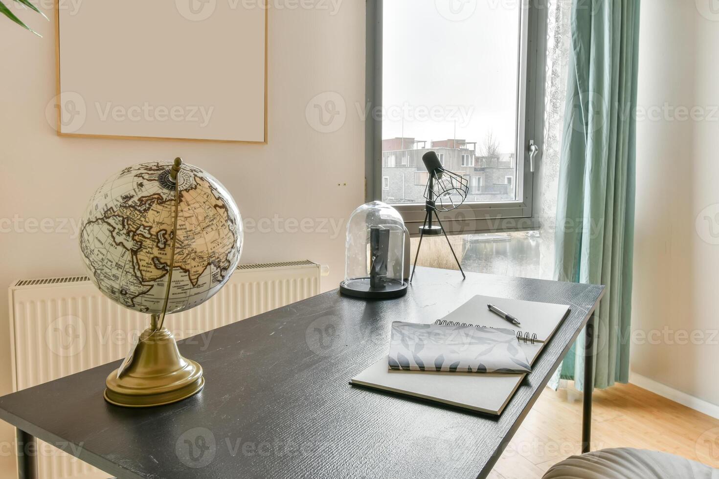 A desk with a globe, notebook and pen on it photo