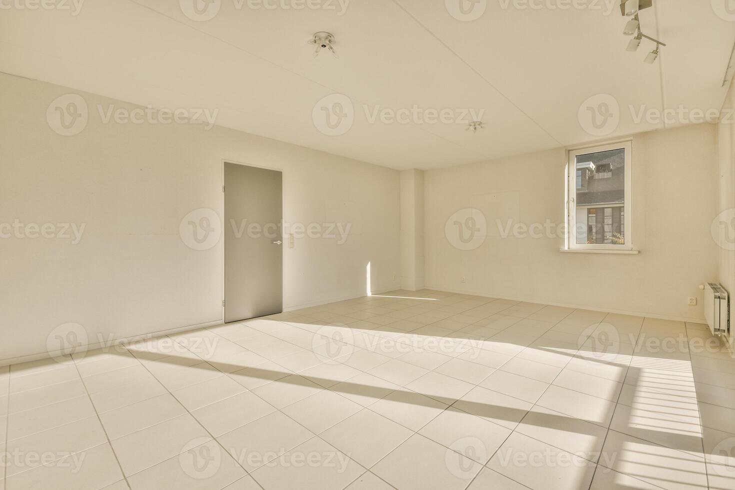 Empty room with white tile floor and large windows photo