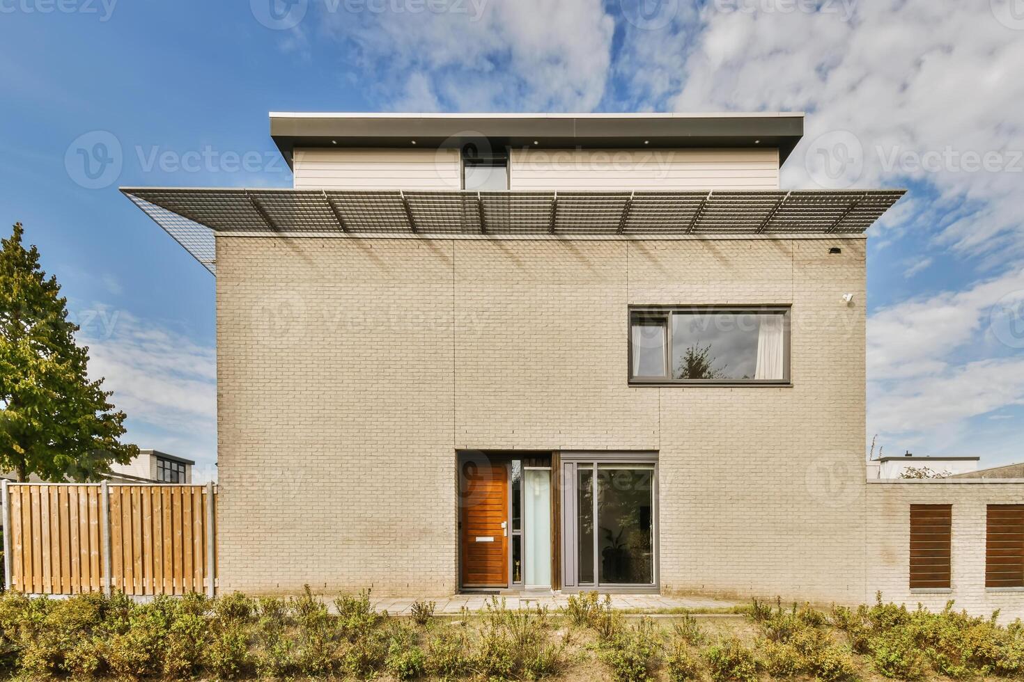 A modern house with a wooden door and a wooden fence photo