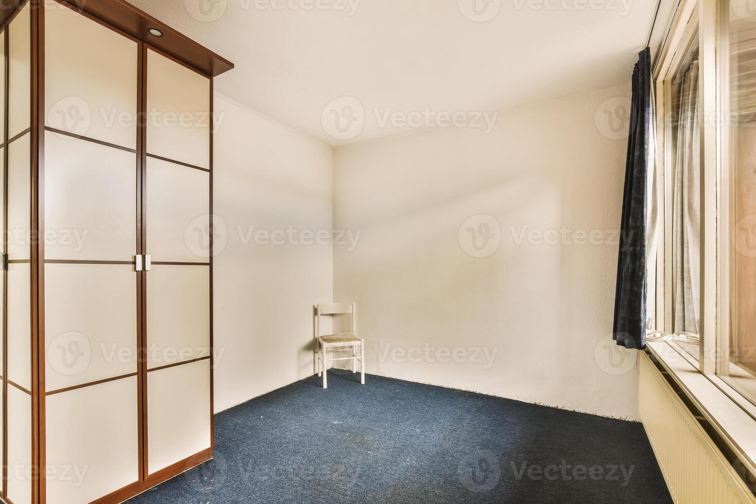 A room with a chair and a cabinet in it photo
