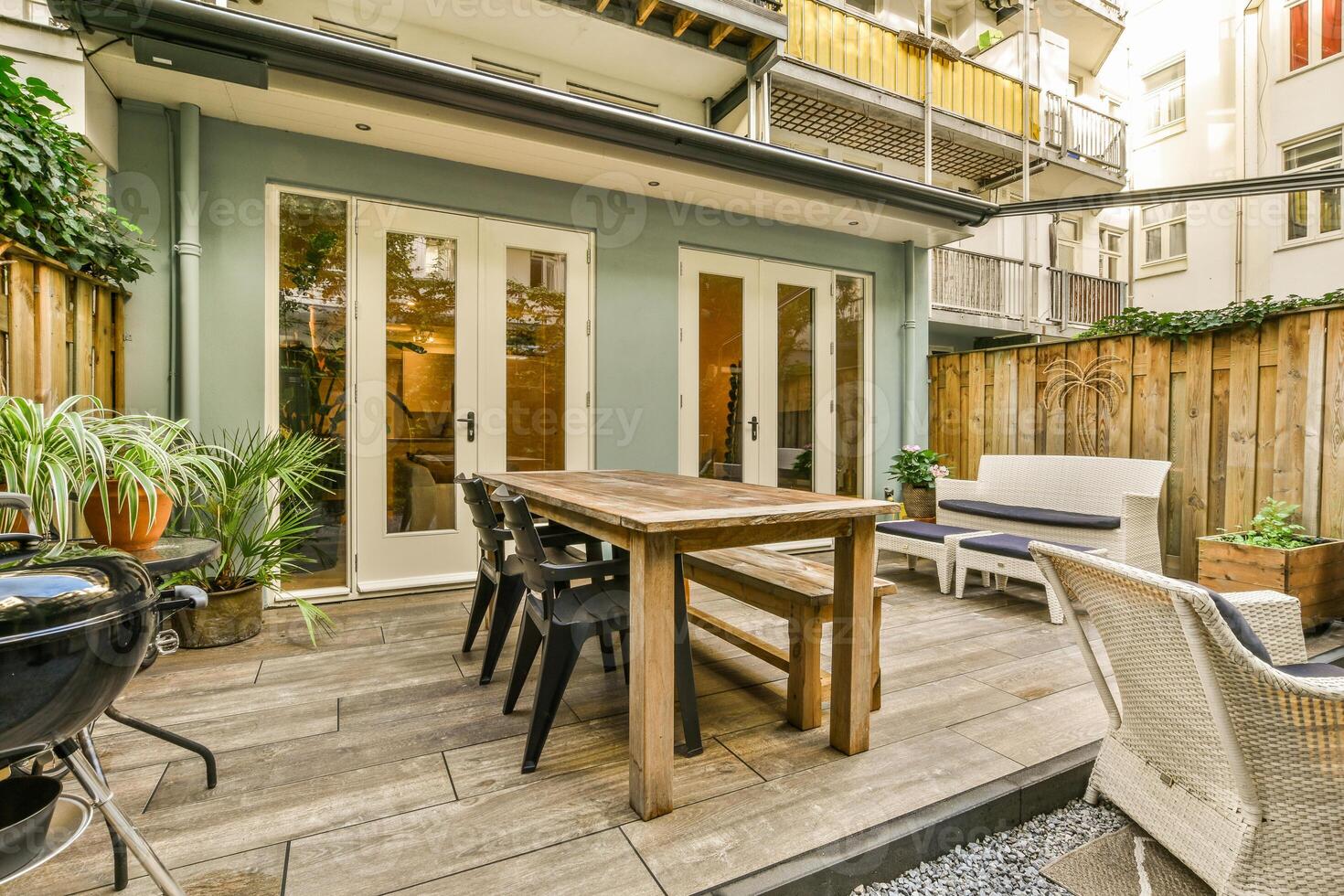 A patio with a table, chairs and bbq grill photo