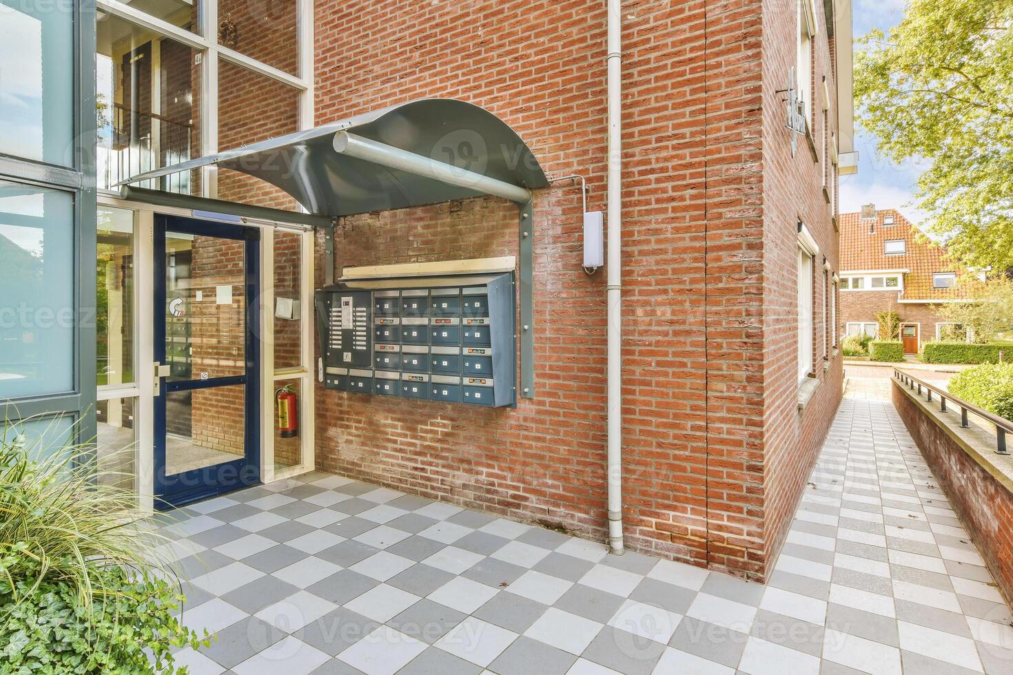 A brick building with a door and a mailbox photo