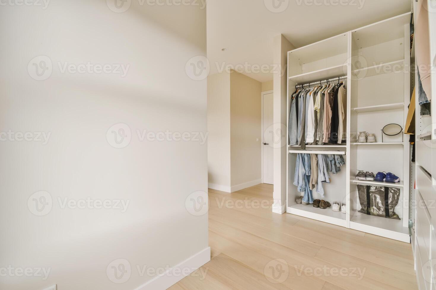 A walk in closet with clothes and shoes photo