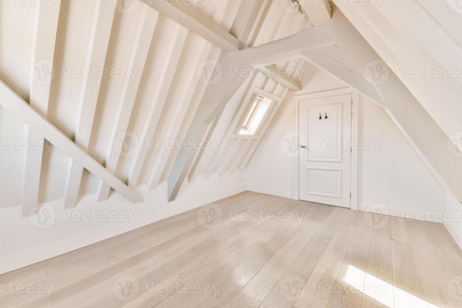 An empty attic with wooden floors and a door photo