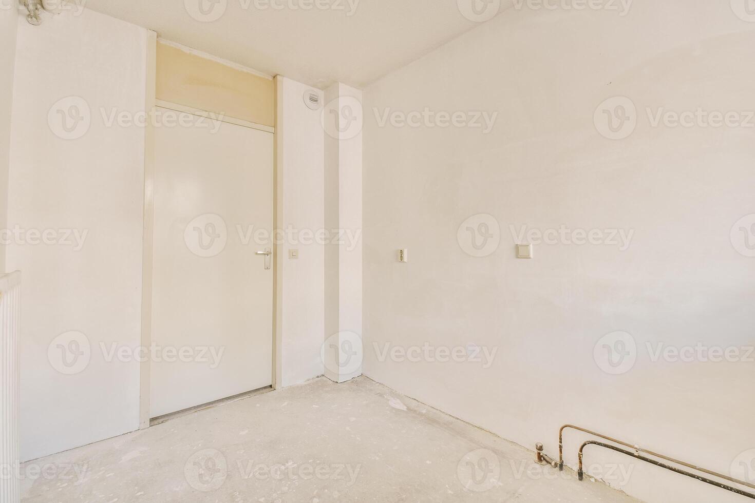 An empty room with a door and a white wall photo
