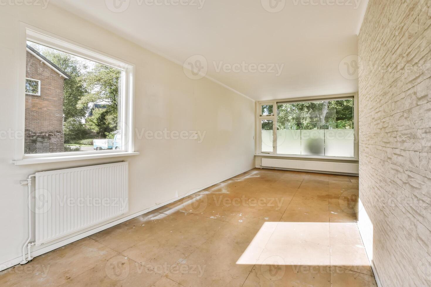 An empty room with a window and a radiator photo