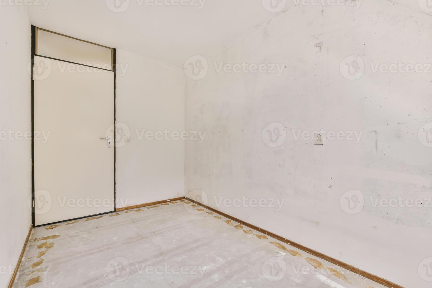 An empty room with a door and a wall photo