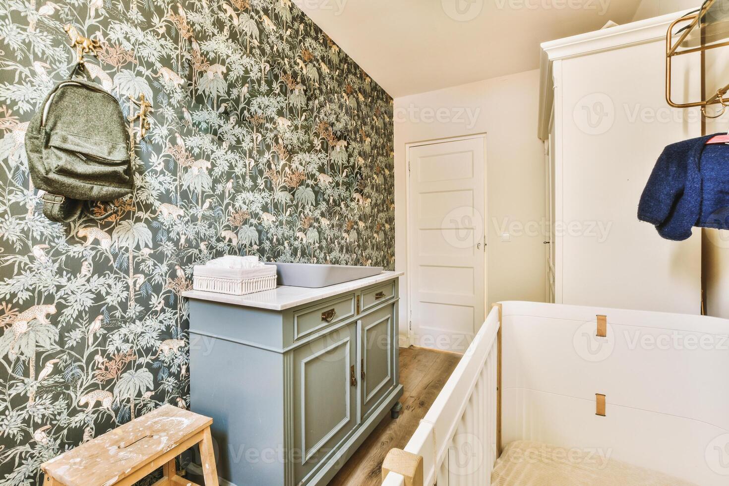 A bathroom with a green wallpaper and a blue crib photo