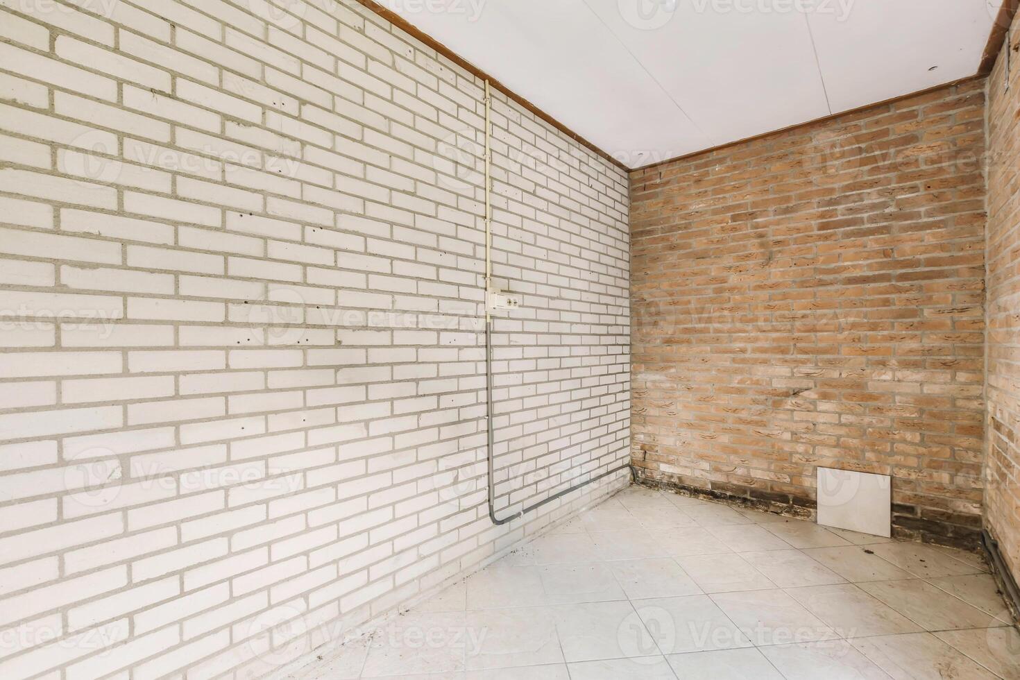 An empty room with brick walls and a white radiator photo