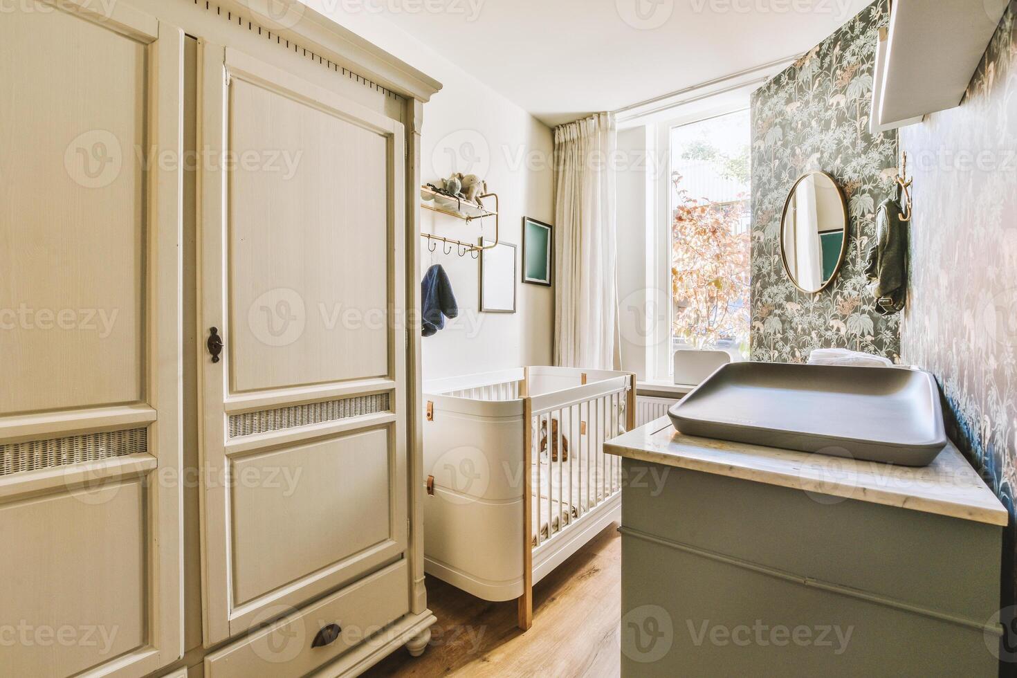 A baby's room with a crib, dresser and mirror photo