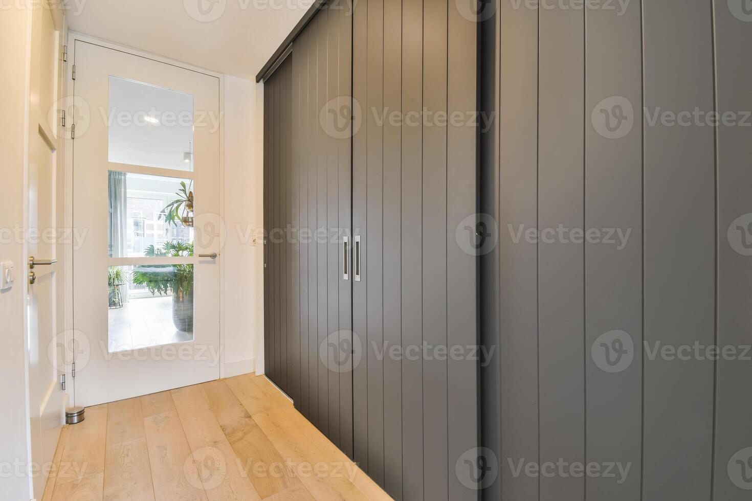 A hallway with wooden floors and a sliding door photo