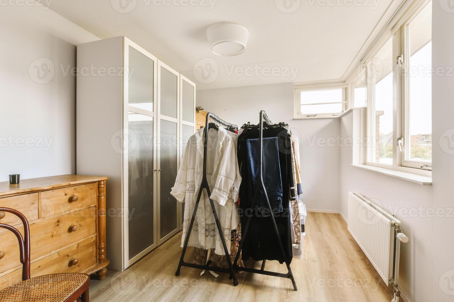 A bedroom with a closet and a dresser photo