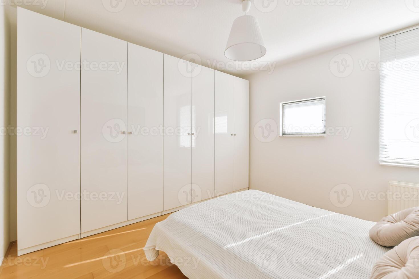 A bedroom with white cabinets and a bed photo
