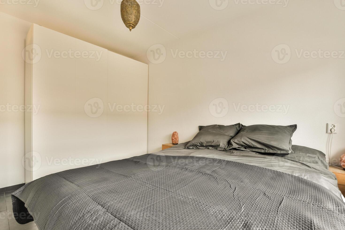 A bed in a bedroom with a white wall photo