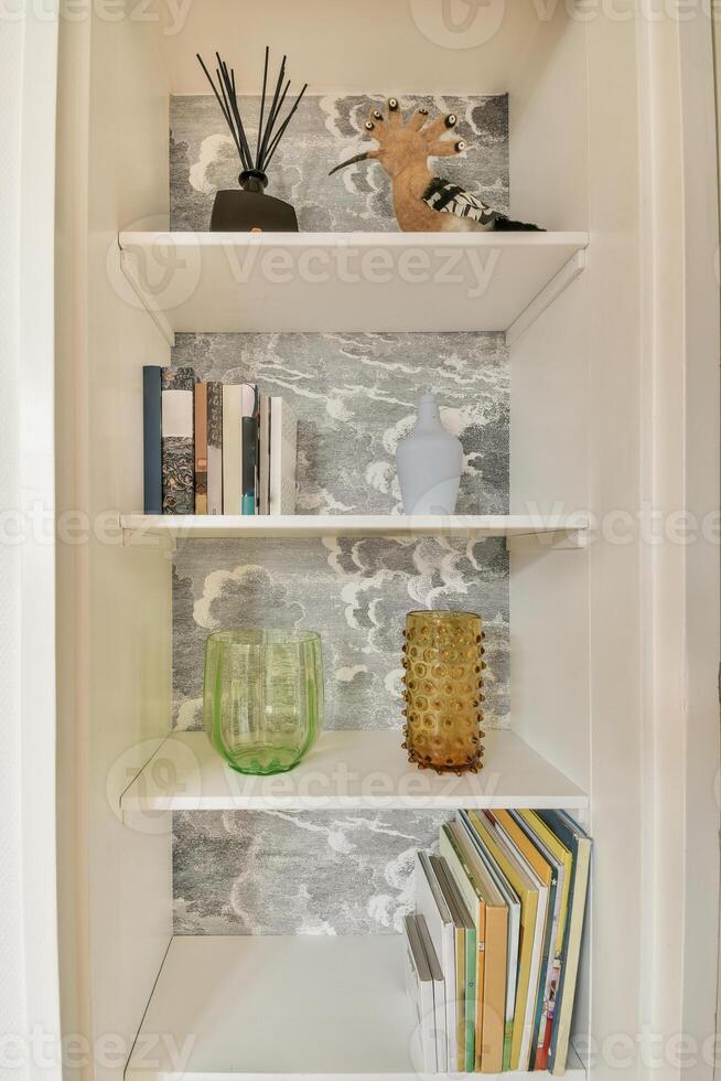 A white shelf with books and vases on it photo