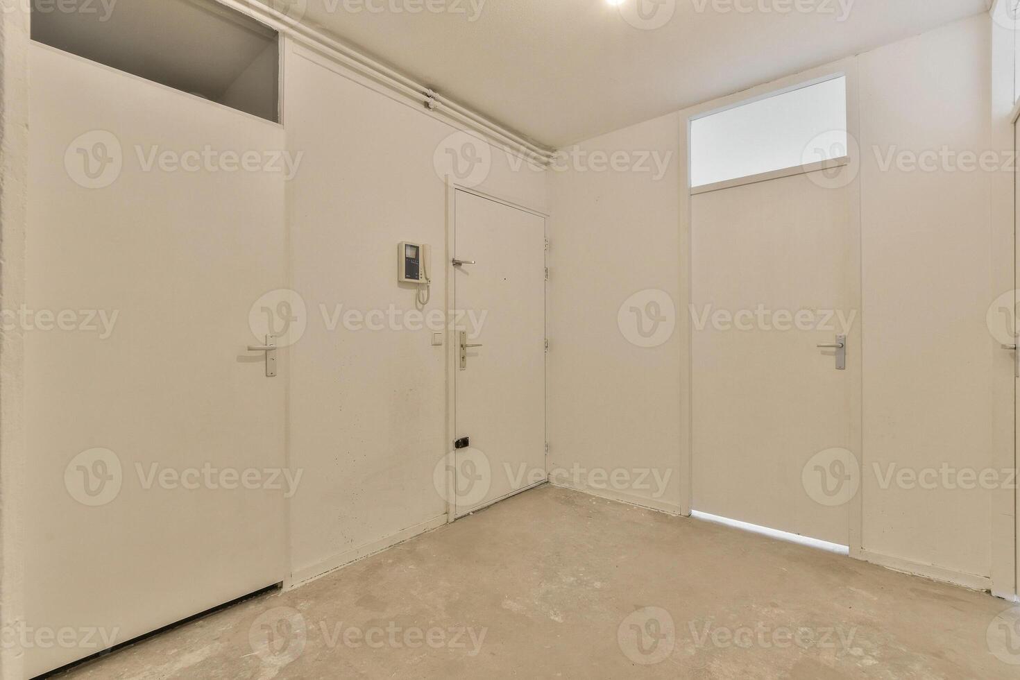 A white room with two doors and a window photo